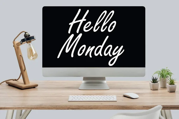 Сучасне робоче місце з вітальним повідомленням у понеділок на моніторі комп'ютера на дерев'яному столі ізольовано на сірому — стокове фото