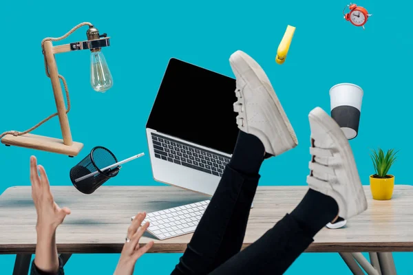 Cropped view of woman levitating in air with laptop and stationery at workplace isolated on turquoise — Stock Photo