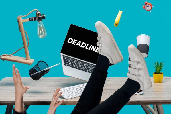 Cropped view of girl levitating in air with laptop with deadline lettering on screen and stationery at workplace isolated on turquoise — Stock Photo