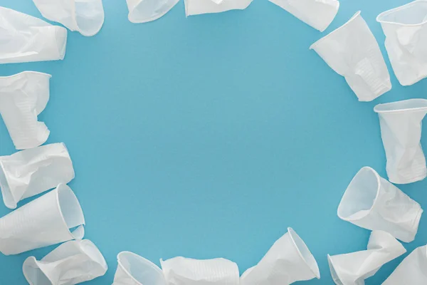 Top view of white plastic cups on blue background with copy space — Stock Photo