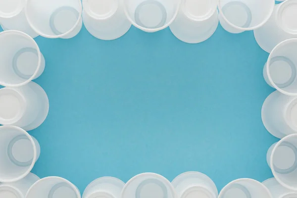 Top view of white plastic cups on blue background with copy space — Stock Photo