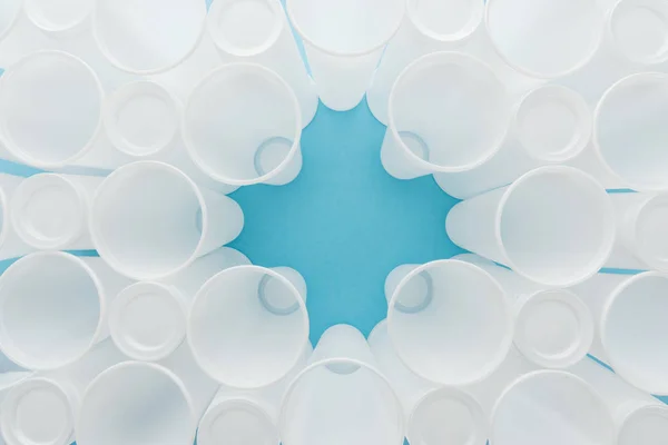 Top view of white plastic cups on blue background with copy space — Stock Photo