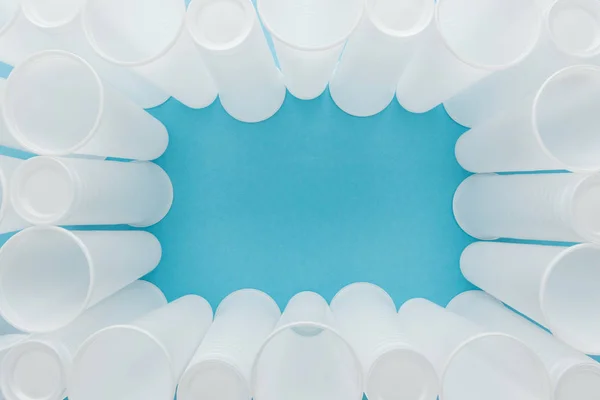 Top view of white plastic cups on blue background with copy space — Stock Photo