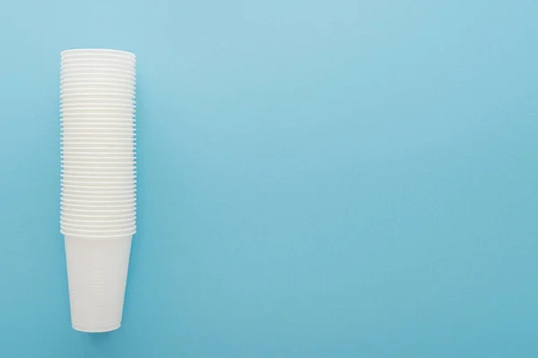 Top view of white plastic cups on blue background with copy space — Stock Photo