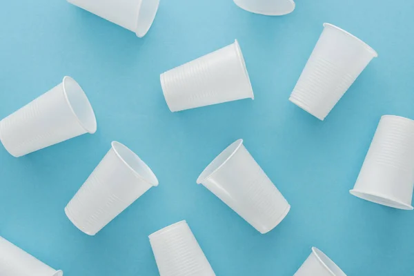 Top view of white and plastic cups on blue background — Stock Photo