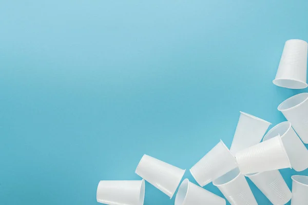 Top view of white plastic cups on blue background with copy space — Stock Photo