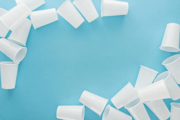 Top view of white plastic cups on blue background with copy space — Stock Photo