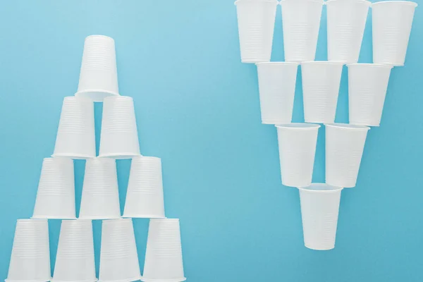 Flat lay with white plastic cups isolated on blue with copy space — Stock Photo