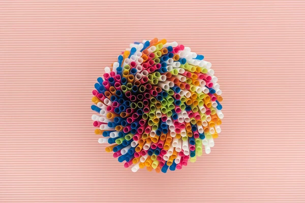 Vue de dessus de pailles en plastique colorées et lumineuses isolées sur rose — Photo de stock