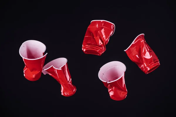 Top view of bright and colorful, red plastic cups isolated on black with copy space — Stock Photo