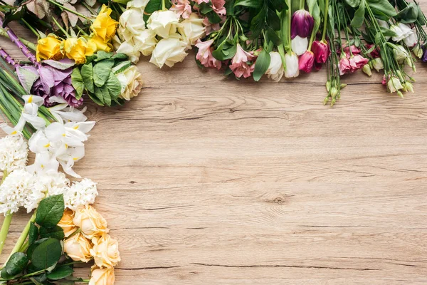 Top view of fresh colorful flowers on wooden surface — Stock Photo