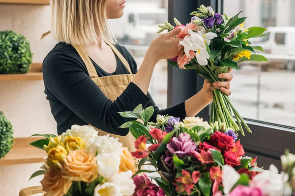 Vista recortada de floristería en delantal que sostiene el ramo en la tienda de flores - foto de stock