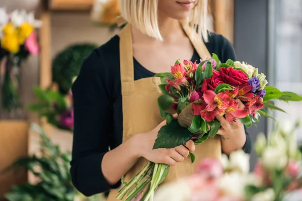 Zugeschnittene Ansicht des Blumenhändlers in Schürze mit Blumenstrauß im Blumenladen — Stockfoto