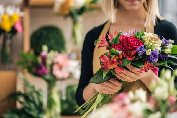 Обрізаний вид флориста в фартусі, що тримає букет в квітковому магазині — стокове фото