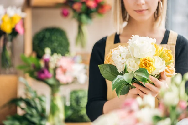 Vista cortada de florista em avental segurando buquê na loja de flores — Fotografia de Stock