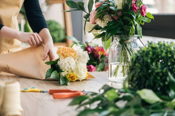 Vue partielle de fleuriste faisant bouquet dans la boutique de fleurs — Photo de stock