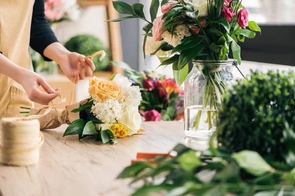 Частковий вигляд флориста, який робить букет у квітковому магазині — стокове фото