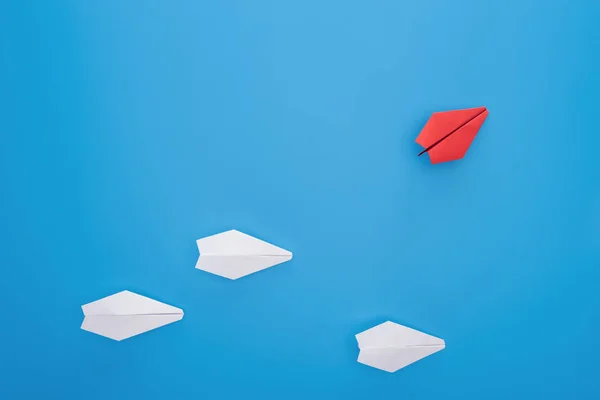 Flat lay com aviões de papel branco e vermelho em azul — Fotografia de Stock
