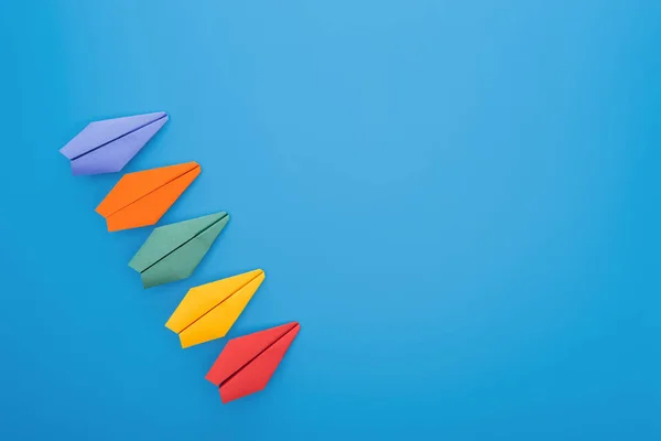 Flache Lage mit bunten Papierfliegern auf blauer Oberfläche — Stockfoto
