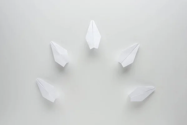 Flat lay with white paper planes on grey surface — Stock Photo