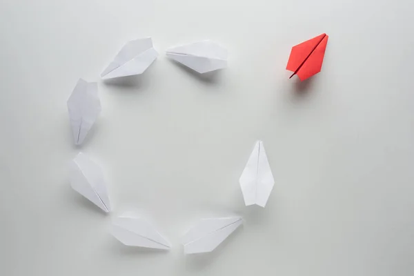 Flat lay with white and red paper planes on grey surface — Stock Photo