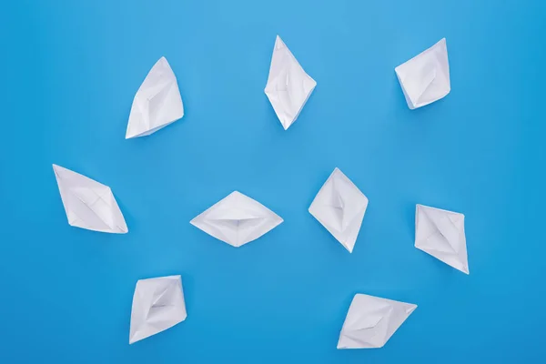 Top view of white paper boats on blue surface — Stock Photo