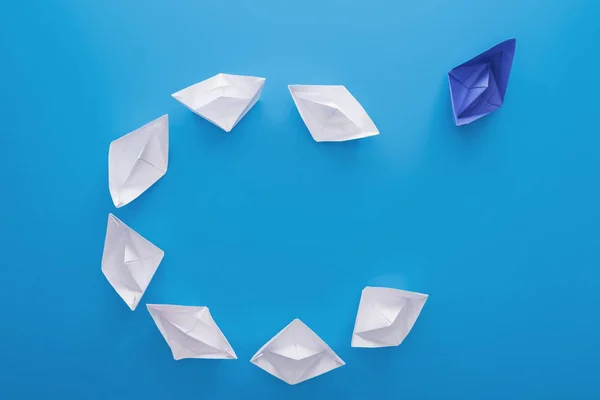 Puesta plana con barcos de papel blanco y azul sobre azul - foto de stock