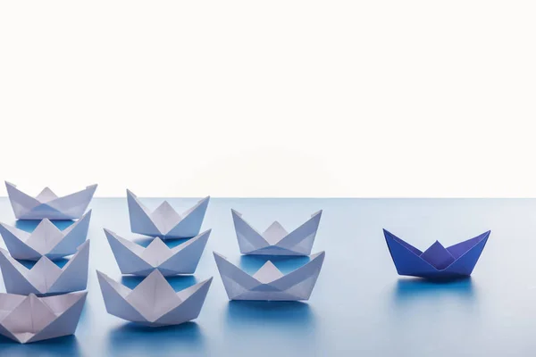 Barcos de papel na superfície azul clara no fundo branco — Fotografia de Stock