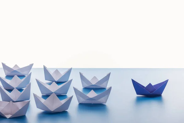 Bateaux en papier sur fond bleu clair sur fond blanc — Photo de stock