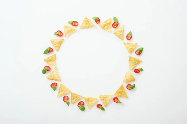 Top view of tasty nachos and sliced chili peppers with basil on white background with copy space — Stock Photo