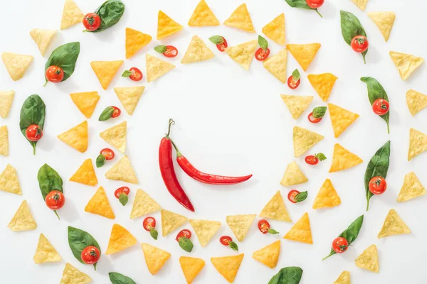 Blick von oben auf leckere Nachos und geschnittene Chilischoten mit Basilikum und Kirschtomaten — Stockfoto