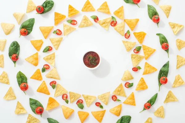 Top view of tasty nachos, sauce and sliced chili peppers with basil and cherry tomatoes — Stock Photo