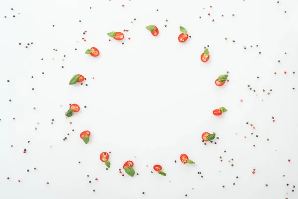 Posa piatta con spezie e peperoncini tagliati a fette con foglie di basilico su fondo bianco con spazio copia — Foto stock