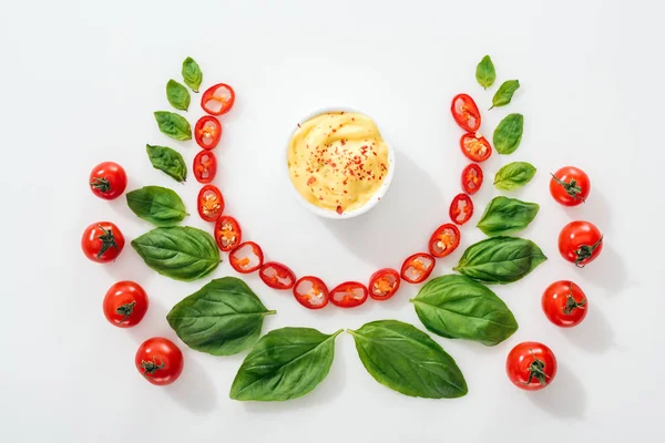 Plat avec des piments coupés, feuilles de basilic, sauce et tomates cerises mûres — Photo de stock