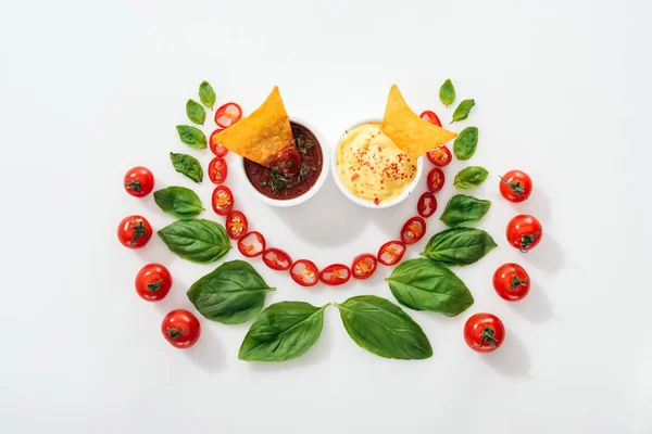 Вид зверху на нарізаний перець чилі, листя базиліка, начос в соусах і стиглі вишневі помідори — стокове фото
