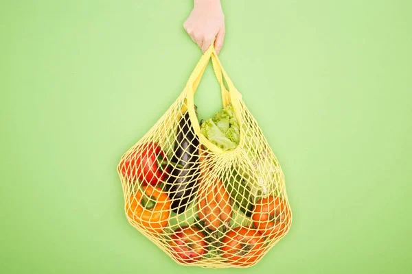 Vue recadrée de femme tenant sac à ficelle avec des légumes crus — Photo de stock