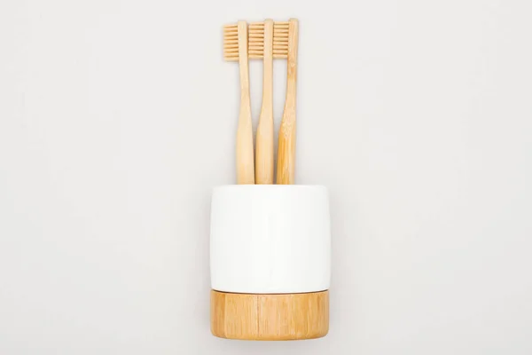 Натуральные бамбуковые зубные щетки стоят на сером фоне — стоковое фото