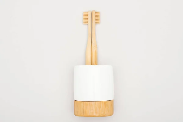 Bamboo toothbrushes in stand on grey background — Stock Photo