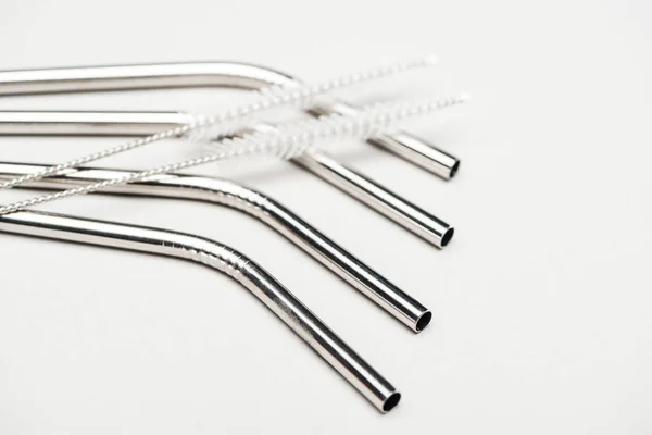 Close up view of of stainless steel straws and cleaning brushes isolated on grey — Stock Photo