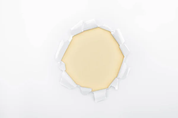 Buraco rasgado em papel branco texturizado sobre fundo de marfim — Fotografia de Stock