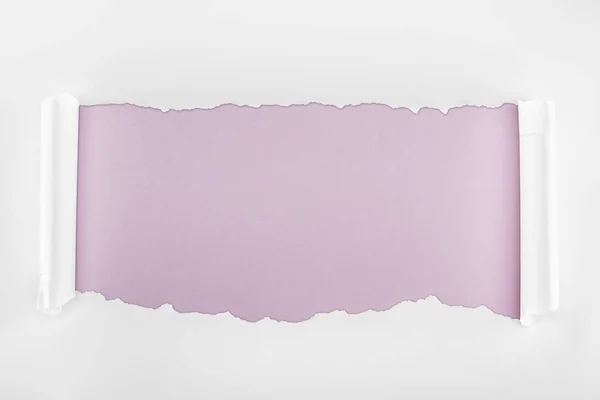 Papel branco texturizado esfarrapado com bordas de onda no fundo roxo claro — Fotografia de Stock