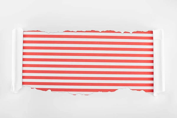 Ragged textured white paper with curl edges on red striped background — Stock Photo