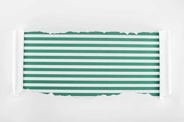 Papier blanc texturé déchiqueté avec bords bouclés sur fond rayé vert — Photo de stock