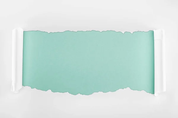 Zerlumptes texturiertes weißes Papier mit Lockenrändern auf hellblauem Hintergrund — Stockfoto