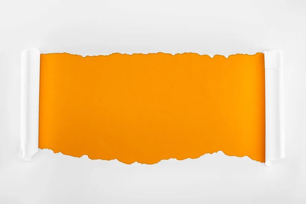 Papel blanco texturizado rasgado con bordes rizados sobre fondo naranja - foto de stock