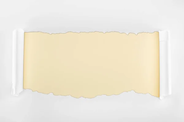 Рваний текстурований білий папір з завитими краями на бежевому фоні — стокове фото