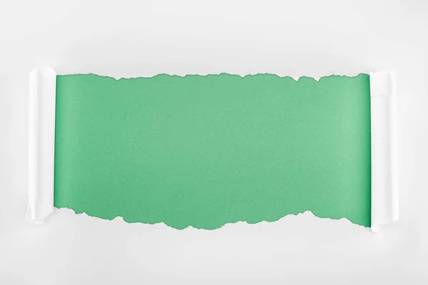 Papier blanc texturé déchiré avec bords bouclés sur fond vert clair — Photo de stock