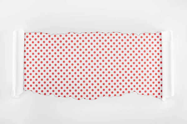 Ripped white textured paper with curl edges on red dotted background — Stock Photo