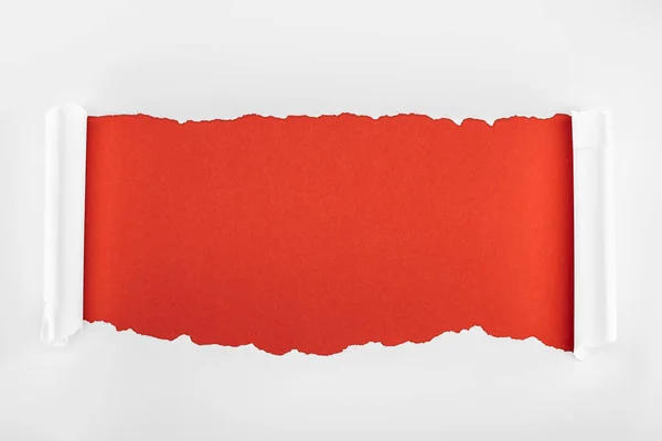 Papier texturé blanc déchiré avec bords bouclés sur fond rouge — Photo de stock