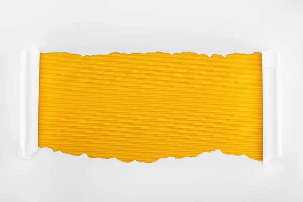 Ripped white textured paper with curl edges on yellow striped background — Stock Photo